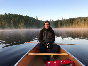 Smiling while sitting in the back of a canoe