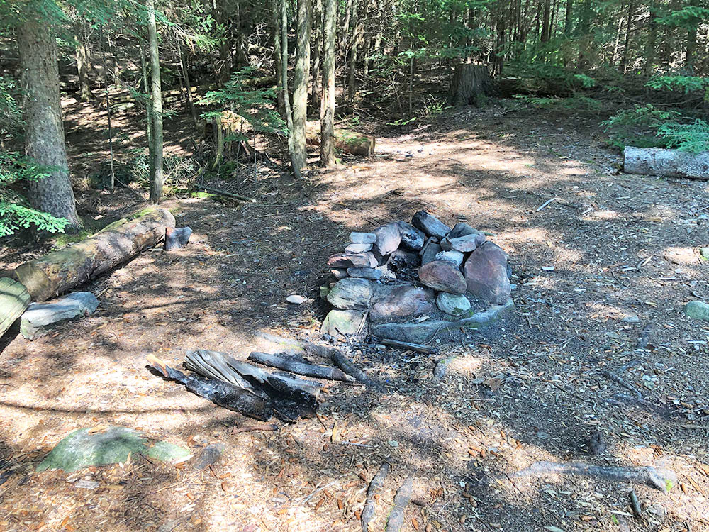 Fire pit and lack of seating at a campsite on Rence Lake in Algonquin Park