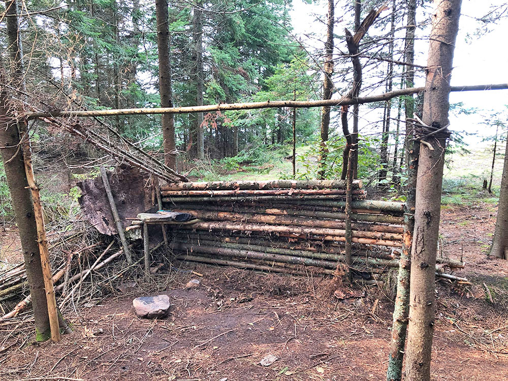 Man made shelter from wood logs and branches behind campsite 3 on Big Trout Lake
