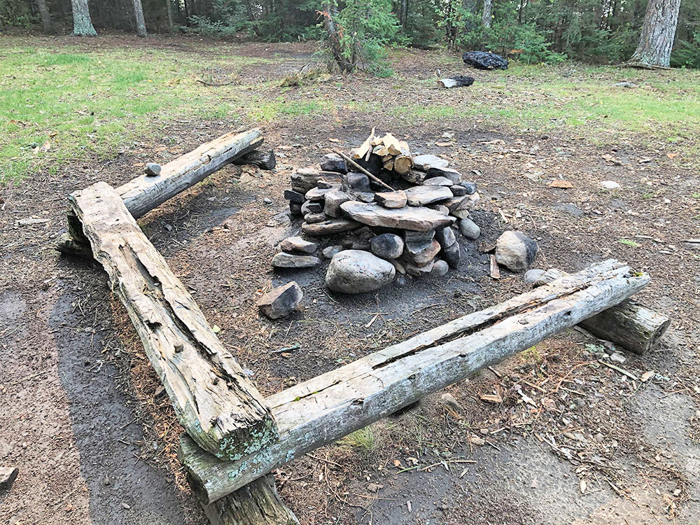 Fire pit and seating area of campsite 4 on Big Trout Lake in Algonquin Park