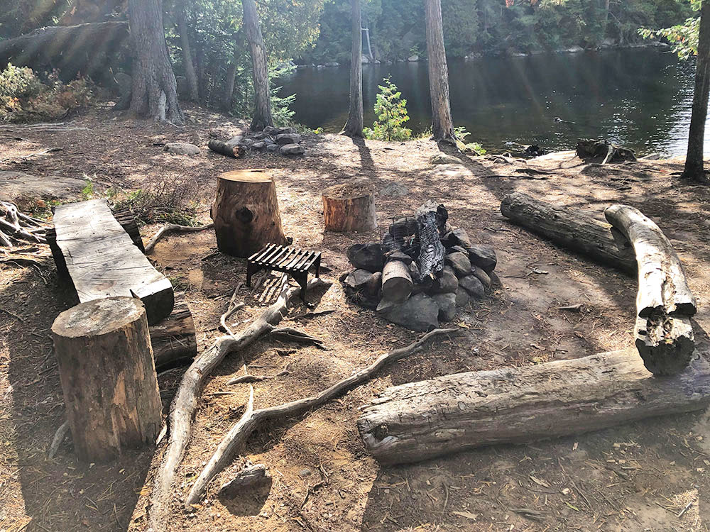 Fire pit and seating area for campsite 28 on Burnt Island Lake