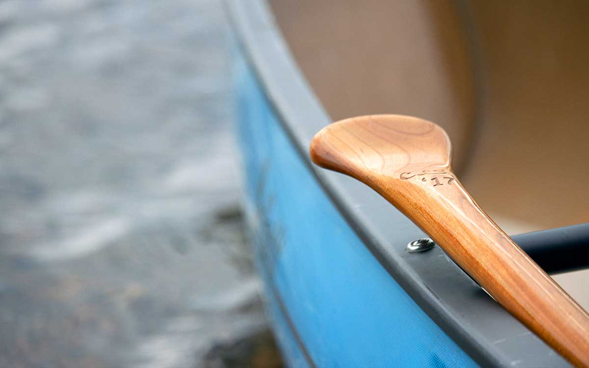Renting Canoes in Algonquin Park - Close up of a blue solo canoe and canoe paddle