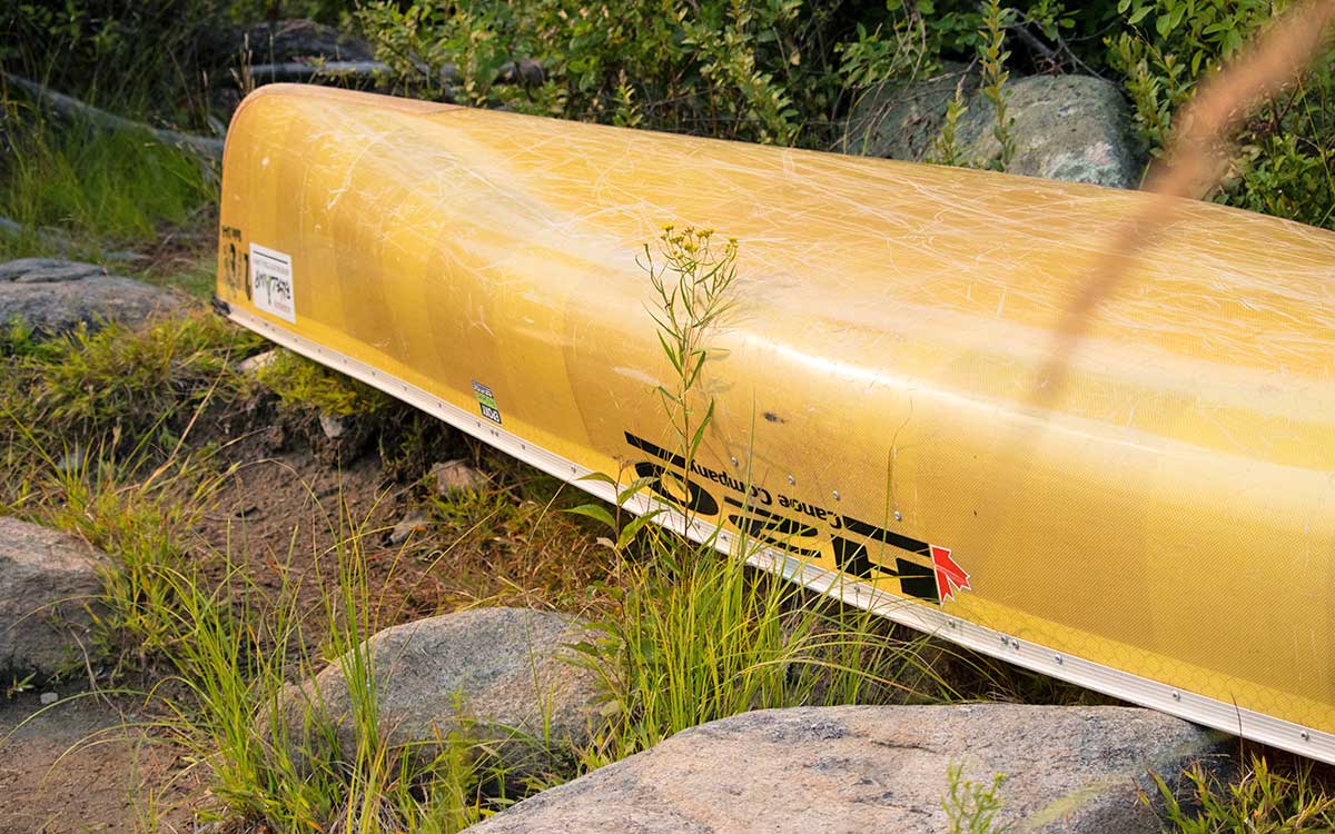Renting Canoes in Algonquin Park - Overturned yellow H2O Canoe at front of campsite in Algonquin Park